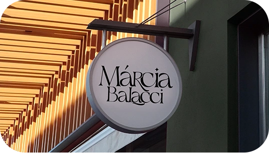Marca Márcia Balacci aplicada na placa circular de uma fachada.